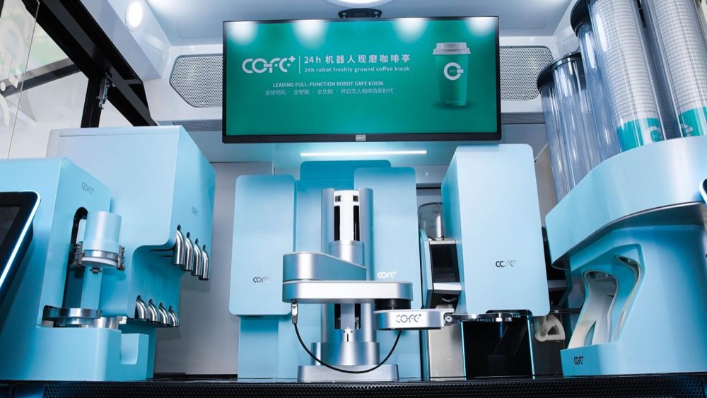 Robotic coffee workstation preparing drinks inside an automated café kiosk